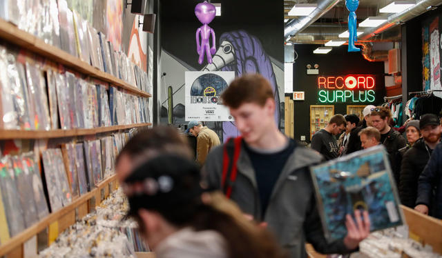 Customers shop at the Shuga Records store during the Record Store Day in Chicago on April 13, 2019. - Record Store Day was founded in 2007 and is now celebrated at stores around the world, with hundreds of recording and other artists participating in the day by making special appearances, performances, meet and greets with their fans, the holding of fund raisers for community non-profits, and the issuing of special vinyl releases. (Photo by KAMIL KRZACZYNSKI / AFP) (Photo credit should read KAMIL KRZACZYNSK
